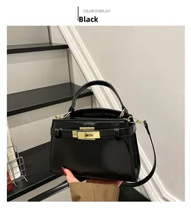 Detailed view of black patent leather crossbody bag with gold-tone metal twist lock closure
