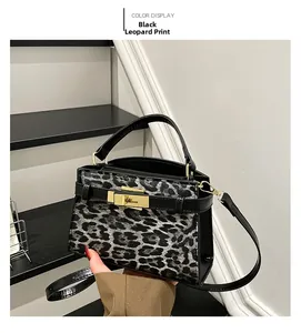 Detail of leopard print handbag with gold rotating lock and black leather handle