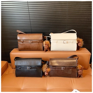 Detail view of vintage buckle shoulder bags in black, beige, coffee, and tan with horse charms