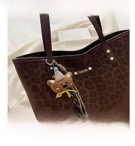 Détail du sac cabas léopard avec rivets dorés et breloque ourson mignonne