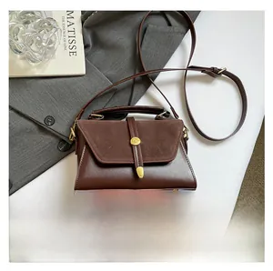 Vue détaillée du grand sac bandoulière marron en patchwork avec boucles dorées et lanière