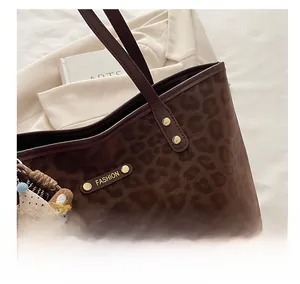 Détail du sac cabas léopard avec plaque en métal doré et pendentif ours en peluche