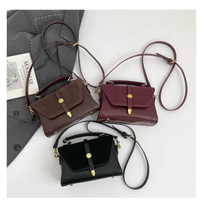 Détail des petits sacs carrés bi-matière avec boucles dorées en marron, bordeaux et noir