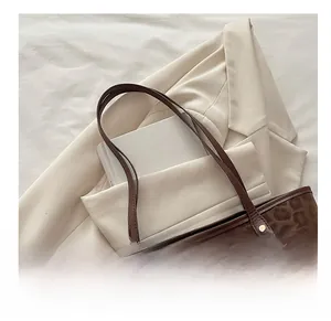 Détail du sac cabas léopard avec poignées en cuir marron et breloque ours mignon