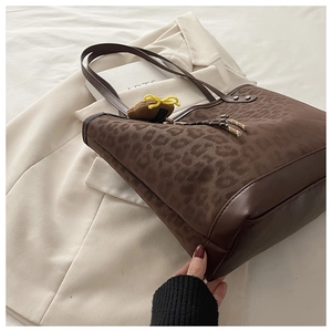 Detailed top view of a large leopard print tote bag with plush texture and leather tassels