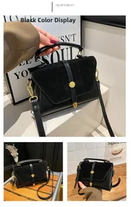Détail de la texture en similicuir noir et de la boucle en métal doré sur le sac à main