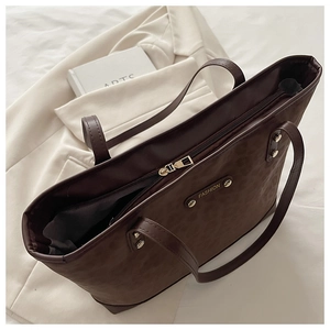 Macro shot of dark brown leopard print tote bag with metal zipper and fashion emblem