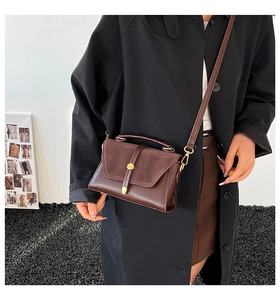 Brown retro shoulder bag in faux leather and suede worn by model in urban setting
