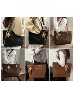 Dettaglio della borsa tote leopardata con logo in metallo e ciondolo a forma di orso