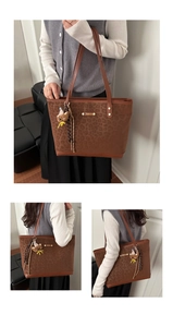 Dettaglio borsa tote leopardata con placca metallica dorata e pendente a forma di orso
