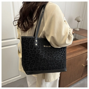 Dettaglio della borsa tote leopardata con borchie dorate e tracolla in pelle elegante