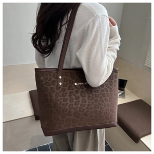 Dettaglio della borsa tote leopardata con placca dorata FASHION e manici in pelle