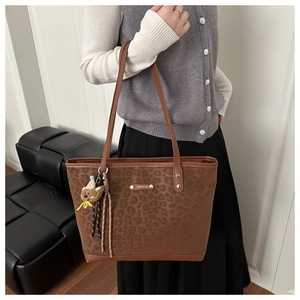 Detail of leopard print tote bag with gold FASHION plaque and cute bear charm