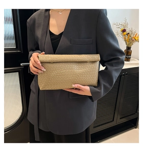 Detail of champagne gold woven leather envelope clutch with intricate crisscross texture