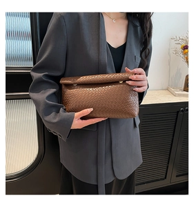 Detail of dark brown woven texture on an oversized envelope clutch for daily fashion