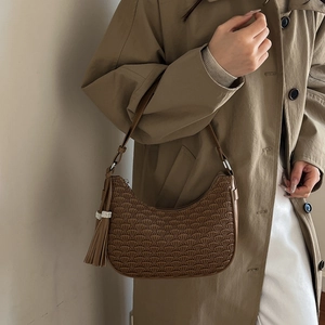 Brown pleated hobo bag with rhinestone tassel shown on a khaki trench coat