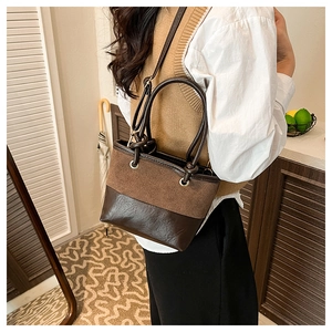Detail of vintage brown bucket bag showing suede and smooth leather texture with metal eyelets