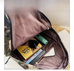 Internal view of camouflage backpack showing purple floral lining and storage compartments