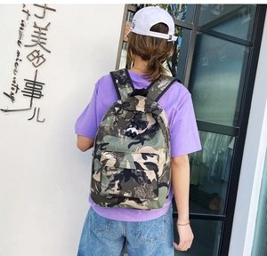 Detail of camouflage nylon backpack featuring adjustable straps and front zipper pocket