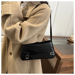 Detail view of the black retro shoulder bag featuring silver buckles and strap design