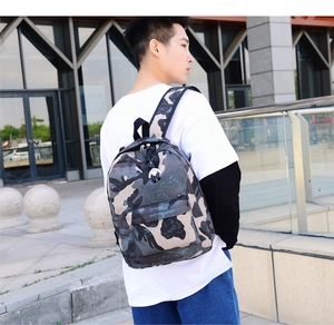 Side view of a durable camouflage backpack worn by a male model in a casual outdoor setting