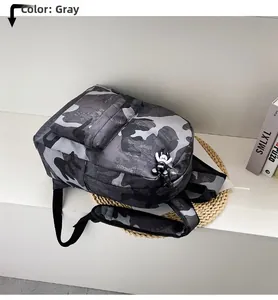 Close-up of a grey camouflage nylon backpack featuring a cute panda zipper charm