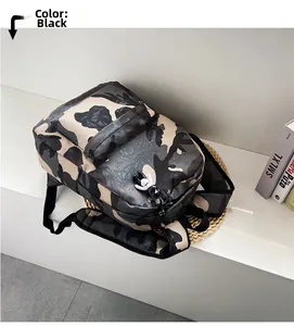 Detail view of the durable camouflage nylon backpack with a black and white doll pendant