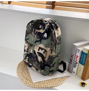 Detail of waterproof camouflage nylon backpack featuring a front pocket and doll pendant