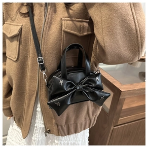 Détail du sac noir avec nœud papillon orné de clous étoiles argentés et cuir mat chic