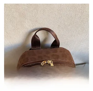 Detail eines Vintage-Leopard-Rucksacks mit gewebtem Griff und goldenen Doppelreißverschlüssen