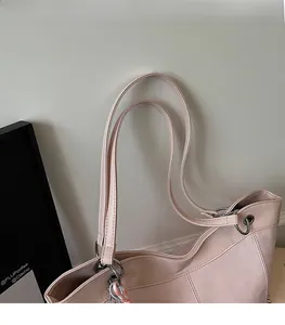 Detail of pink faux leather tote bag showing double shoulder straps and silver metal hardware