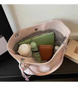 Interior view of large pink suede tote showing striped lining and high storage capacity