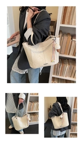 Detail view of cream leather tote bag with plush ice cream pendant in a lifestyle setting