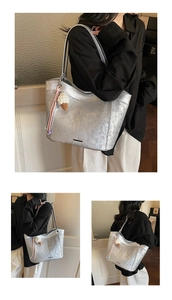 Detail of silver metallic tote bag with crinkled texture and knit ice cream pendant