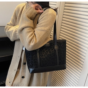 Close-up of leopard print tote bag with leather straps and metal fashion logo