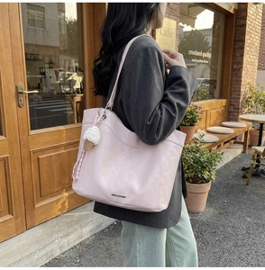 Detail of pink tote bag with textured faux leather and ice cream knit charm accessory