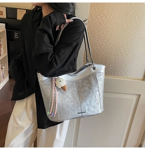 Detail of silver metallic tote bag with ice cream charm and long shoulder strap