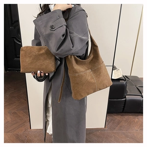 Dettaglio borsa tote in pelle scamosciata marrone con pochette abbinata su modella