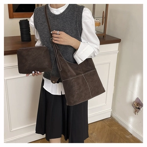 Set tote retrò marrone scuro con texture scamosciata e cuciture a contrasto su modella
