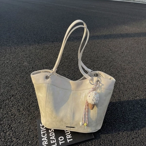 Minimalist beige suede tote bag with long straps and cute ice cream charm on asphalt