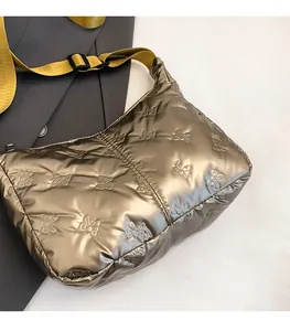 Détail du sac à bandoulière matelassé bronze avec motifs papillons en relief