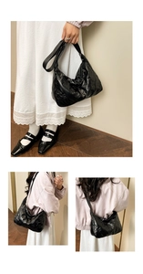 Détail du sac bandoulière noir brillant matelassé avec texture gaufrée 3D et forme croissant