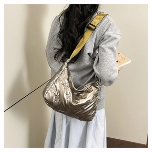 Détail du sac à bandoulière argenté avec nœuds gaufrés et sangle jaune