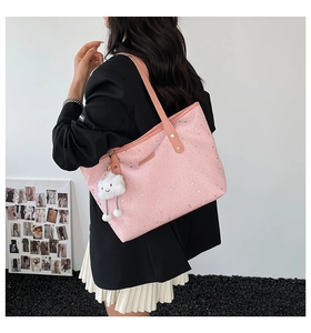 Detail of pink star-patterned tote bag with plush cloud charm on a shoulder strap