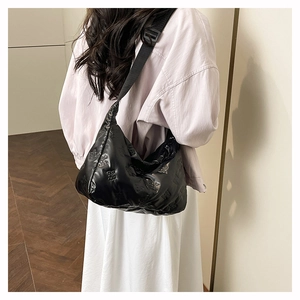 Sac hobo noir brillant avec motif d'ours gaufré et bandoulière réglable sur l'épaule