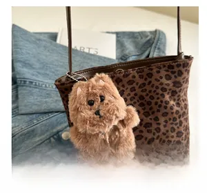 Dettaglio della borsa a secchiello leopardata con ciondolo a cucciolo di peluche marrone