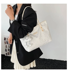 White star pattern tote bag featuring a plush cloud charm and spacious interior design