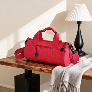 Détail d'un sac de sport rouge avec fermetures noires sur une table en bois rustique