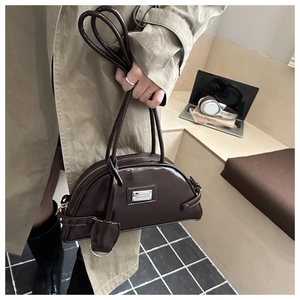 Detail of dark brown glossy crescent handbag with silver logo and chic twin handles
