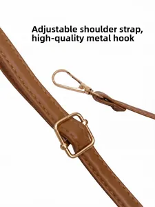 Detail of adjustable brown leather shoulder strap with high-quality gold metal hook